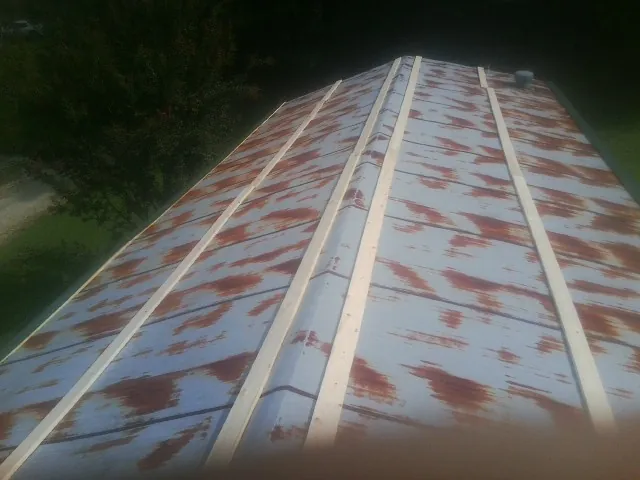 Rusted metal roof panels with new wood purlins before replacement — Storm Damage Roof Repair in Agoura Hills by Roofing Brothers
