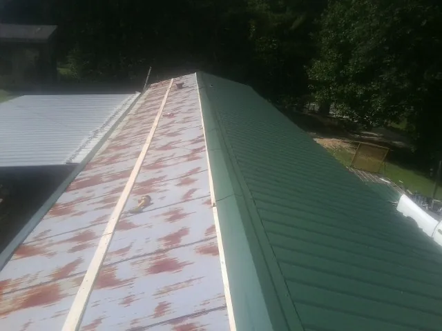 Old rusted panels beside newly installed green metal roofing — Wind Damage Roof Repair by Roofing Brothers in Agoura Hills