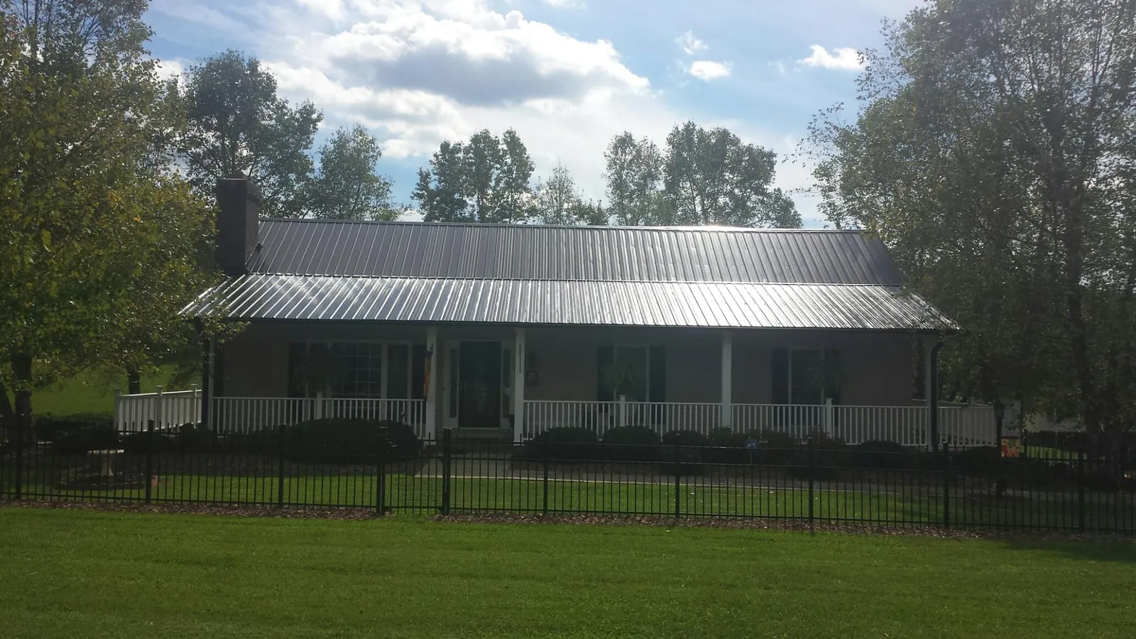 Gray metal roof on a brick ranch with a full width front porch — Gutter Guard Installation work by our crew in Agoura Hills